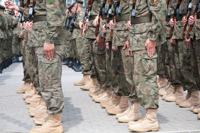 Low section of army soldiers standing on road