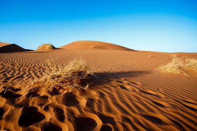 Sand dune in desert against clear blue sky