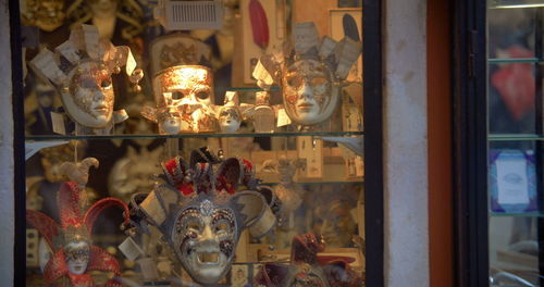 Illuminated candles in store seen through window