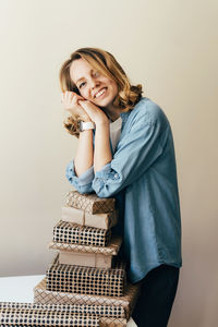 Portrait of a smiling young woman against wall