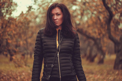 Portrait of beautiful young woman standing in forest