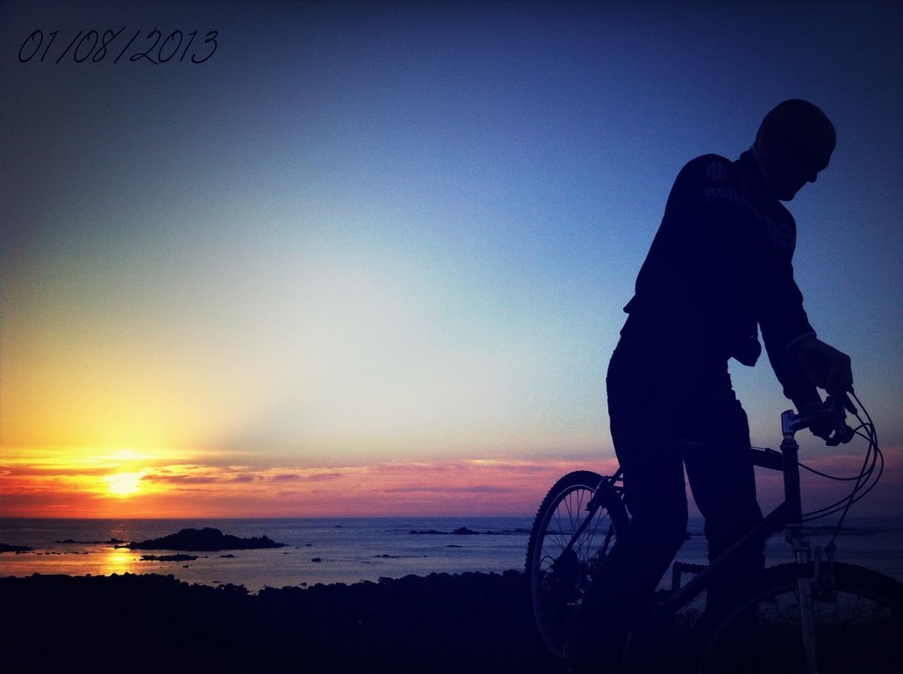 sea, horizon over water, sunset, water, beach, silhouette, sky, shore, scenics, beauty in nature, tranquility, tranquil scene, bicycle, mode of transport, transportation, nature, orange color, idyllic