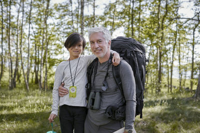 Portrait of a smiling young woman standing in forest