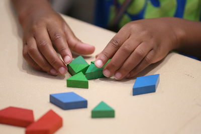 Close-up midsection of girl playing with toy blocks on table