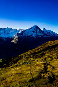 Scenic view of mountains against clear blue sky