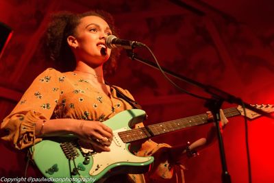 Low angle view of singer playing guitar during concert