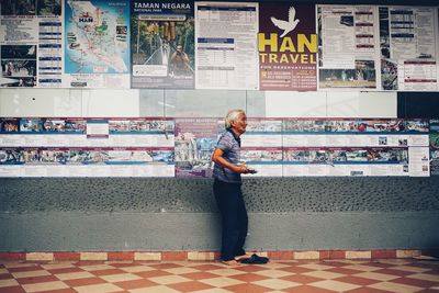 Full length of man standing against wall in store