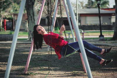 Full length of woman on swing in playground