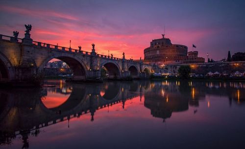 Reflection of bridge in river at sunset