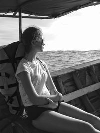 Thoughtful woman with backpack traveling in boat