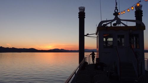 Silhouette ship in sea against sky during sunset