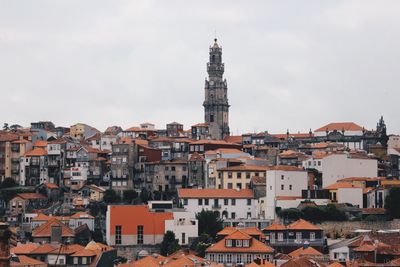 Buildings in city against cloudy sky