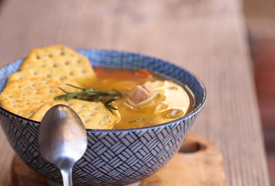 Close-up of soup with crackers on wooden table