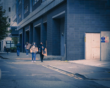 People walking on street against buildings in city