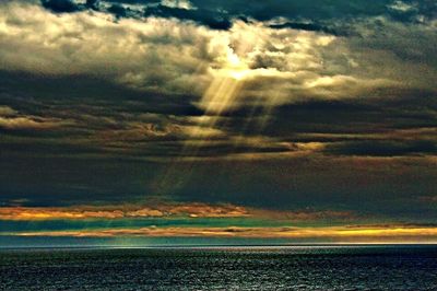 Scenic view of sea against cloudy sky during sunset