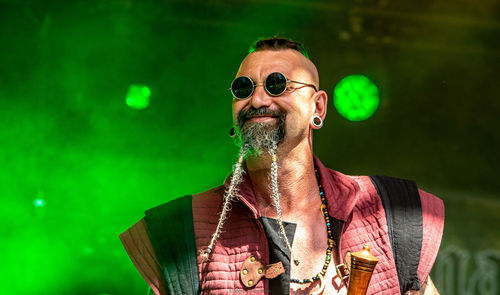 Low angle view of man wearing sunglasses while standing against stage lights