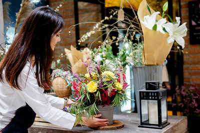 Side view of florist arranging flowers in store