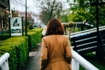 Rear view of woman standing by tree