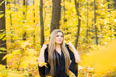 Portrait of young woman standing in forest