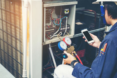 Midsection of man using phone while working in office