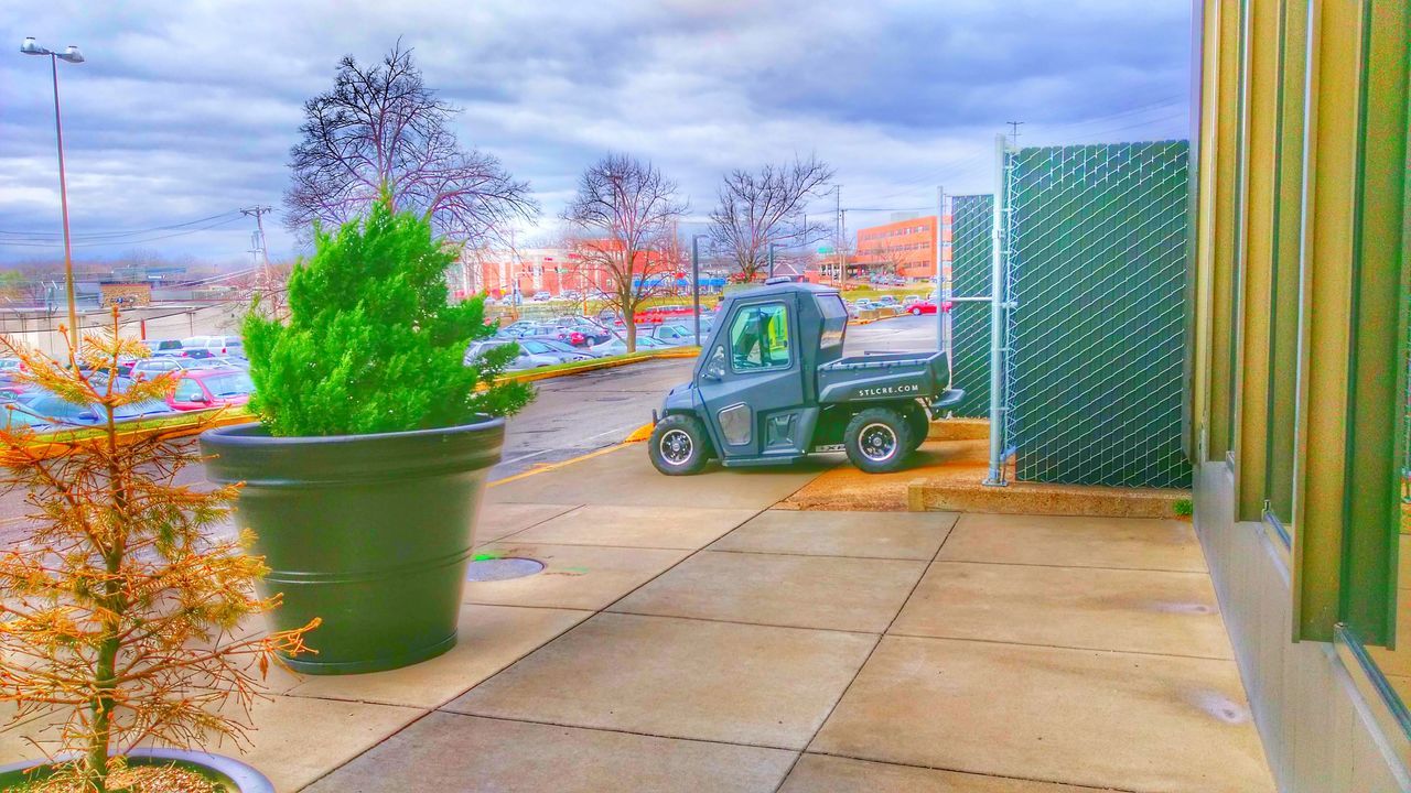 sky, building exterior, architecture, built structure, tree, cloud - sky, cloudy, growth, cloud, city, plant, potted plant, outdoors, green color, day, no people, palm tree, modern, nature, transportation