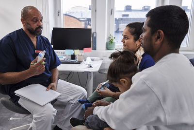 Male doctor talking to family with children