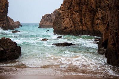 Scenic view of rocks in sea against sky