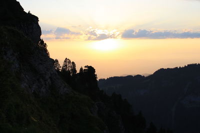 Scenic view of silhouette mountains against sky during sunset