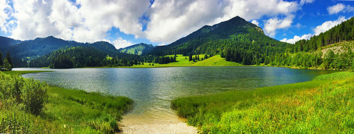 Panoramic view of lake amidst field against sky