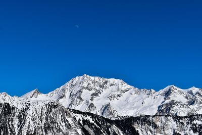 Scenic view of snowcapped mountains against clear blue sky