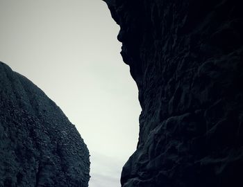 Low angle view of cliff against clear sky