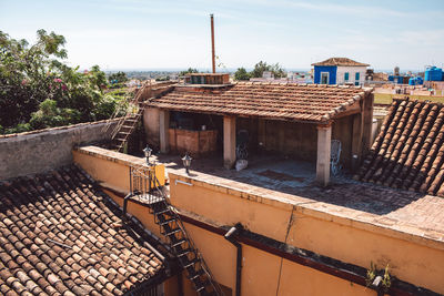 Old house by building against sky