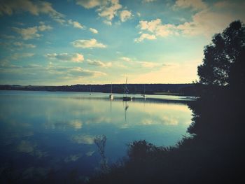 View of calm lake against cloudy sky