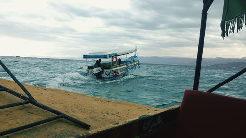 Boat sailing in sea against sky