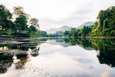 Scenic view of lake by trees against sky