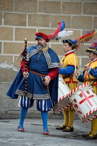 Men with umbrella standing against built structure