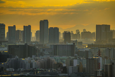 Skyscrapers in city against sky during sunset