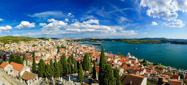 High angle view of townscape by sea against sky