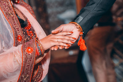 Midsection of couple holding hands