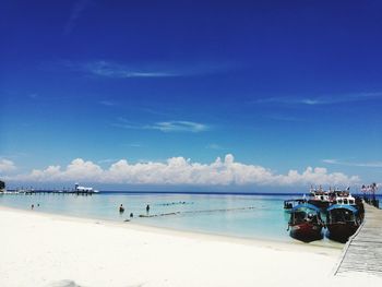 Scenic view of beach against blue sky