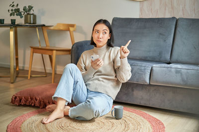 Portrait of young woman sitting on sofa at home