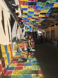 Full length of woman on multi colored buildings in city