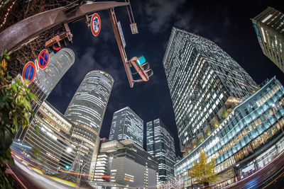 Low angle view of illuminated buildings in city at night