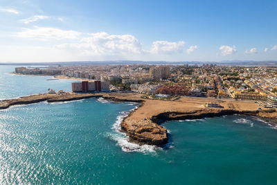 Aerial view of sea and buildings against sky