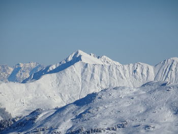 Scenic view of snowcapped mountains against clear blue sky