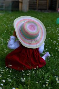 Rear view of woman wearing hat on field