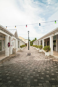 Footpath amidst buildings against sky