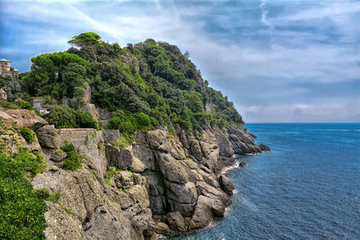 Rock formations by sea against sky