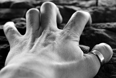 Cropped hand holding stone wall