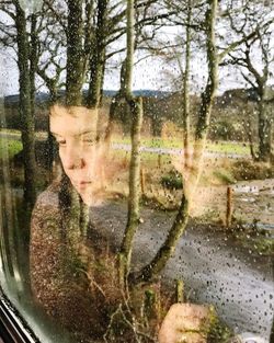 Woman seen through wet window in rainy season